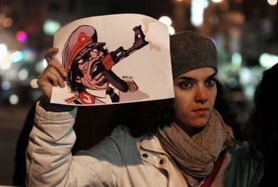 A Carlos Latuff cartoon of Gaddafi sighted in a Ramallah rally in solidarity with the Libyan people, 22 February 2011. Photo by Abbas Momani/AFP.
