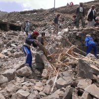 Villagers scour rubble for belongings scattered during the bombing of Hajar Aukaish