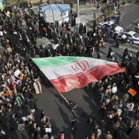 A demonstrator waves a huge Iranian flag during a pro-government rally
