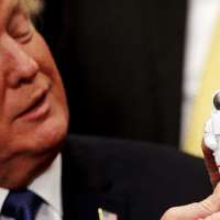 President Donald Trump holds a toy astronaut as he participates in a signing ceremony for Space Policy Directive at the White House. (Reuters Photo)