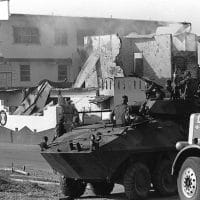 Marines stand guard outside a destroyed Panamanian Defense Force building during the first day of Operation Just Cause, on 20 December, 1989.