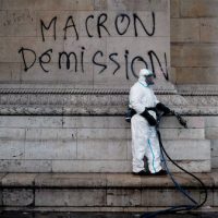 A worker is about to clean a graffiti reading ” Macron resignation” on the Arc de Triomphe the day after a protest, in Paris, , Dec. 2, 2018. A protest against rising taxes and the high cost of living turned into a riot in the French capital, as activists torched cars, smashed windows, looted stores and tagged the Arc de Triomphe with multi-colored graffiti. Thibault Camus. | AP