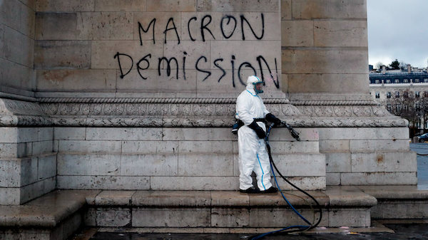 | A worker is about to clean a graffiti reading Macron resignation on the Arc de Triomphe the day after a protest in Paris Dec 2 2018 A protest against rising taxes and the high cost of living turned into a riot in the French capital as activists torched cars smashed windows looted stores and tagged the Arc de Triomphe with multicolored graffiti Thibault Camus | AP | MR Online