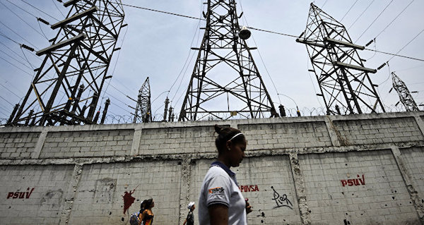 | A woman walks in front of electricity pylons in Caracas Venezuela File | MR Online