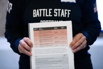 In this Monday, Dec. 16, 2019, photo, a booklet is held up during an exercise run by military and national security officials, for state and local election officials to simulate different scenarios for the 2020 elections, in Springfield, Va. These government officials are on the front lines of a different kind of high-stakes battlefield, one in which they are helping to defend American democracy by ensuring free and fair elections. (AP Photo/Alex Brandon)