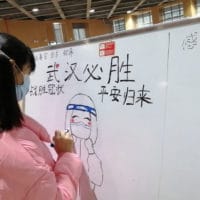 A 10-year-old patient draws on the notice board at a Wuhan hospital every day