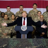 FILE - In this Nov. 28, 2019 file photo, President Donald Trump, center, with Afghan President Ashraf Ghani and Joint Chiefs Chairman Gen. Mark Milley, behind him at right, addresses members of the military during a surprise Thanksgiving Day visit at Bagram Air Field, Afghanistan. President Donald Trump starts the new year knee-deep in daunting foreign policy challenges at the same time he'll have to deal with a likely impeachment trial in the Senate and the demands of a reelection campaign. (AP Photo/Alex Brandon, File)