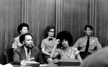 | Angela Davis raises her fist to give her power salute as she sits in the courtroom at Marin Civic Center in San Rafael Ca on March 16 1971 AP Photo | MR Online