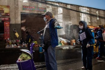 Shoppers at the market pay to be disinfected. Rodríguez Market, La Paz, Bolivia, 2020. Carlos Fiengo