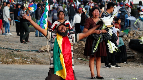 | A coca leaf producer kneels holding a bible with his arms outspread asking police to open the way so a march by supports of Evo Morales may continue to Cochabamba Bolivia Nov 16 2019 Juan Karita | AP | MR Online