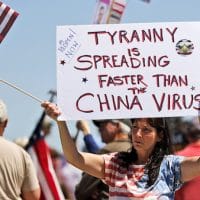 A woman holds a sign as she attends a rally outside the Missouri Capitol to protest stay-at-home orders put into place due to the COVID-19 outbreak in Jefferson City on Tuesday. Jeff Roberson | AP