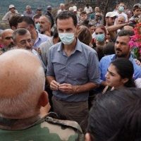 A handout photo made available by the Syrian Arab News Agency (SANA) on 14 October 2020 shows Syrian President Bashar al-Assad surrounded by locals of Mashta al-Helou village in central Syria. | Photo: EFE/EPA/SANA