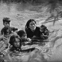 Kyōichi Sawada (Japan), A mother and her children wade across a river in Vietnam to escape U.S. bombing, 1965.