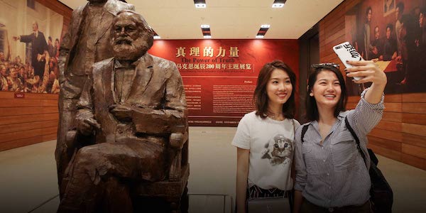 | Header image Two young women take selfies with a statue of Karl Marx and Friedrich Engels during an exhibition commemorating Marxs 200th birthday in Beijing May 5 2018 Chen XiaogenPeople Visual | MR Online