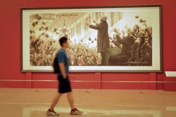 A man walks past an oil painting of Karl Marx during an exhibition in Beijing, May 6, 2018. Du Jia/People Visual