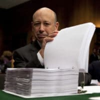 Goldman Sachs Chairman and CEO Lloyd Blankfein examines a report on his company by the Senate Permanent Subcommittee on Investigations before a 2010 hearing on Wall Street investment banks and the financial crisis. (AP)