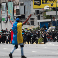 A demonstrator covered with a Venezuelan flag gestures in front of security forces during a protest in Caracas, Venezuela, on March 10, 2020. Carlos Jasso/Reuters