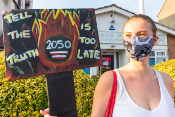 A young woman protests the UK’s target of reaching net zero emissions by 2050, which many believe is too late. Essex, UK, August 10 2020. Avpics/Alamy