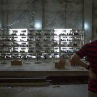 A man shows off equipment inside a Bitcoin mine near Kongyuxiang, Sichuan province, Aug. 12, 2016. Paul Ratje for The Washington Post via Getty Images/People Visual