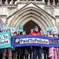 Climate campaigners gather outside the Royal Courts of Justice in London earlier this month. Three members of the Paid to Pollute group have brought a case against the UK government challenging public money going to the oil and gas industry. (Image: Sabrina Merolla / Alamy)