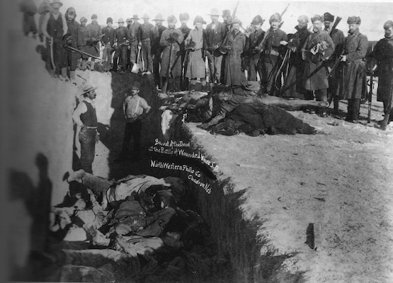 MR Online | Burial of the dead after the massacre of Wounded Knee in South Dakota US Soldiers are shown putting Indians in a common grave some corpses are frozen in different positions Source wikipediaorg | MR Online