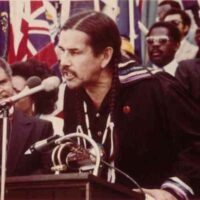 Clyde Bellecourt speaking outside the Ebenezer Baptist Church, Atlanta, GA, 1974. | American Indian Movement Interpretive Center