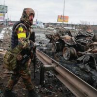 | An armed man stands by the remains of a Russian military vehicle in Bucha close to the capital Kyiv Ukraine Tuesday March 1 2022 AP PhotoSerhii Nuzhnenko | MR Online