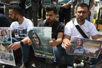 PALESTINIAN JOURNALISTS HOLD POSTERS DISPLAYING AL JAZEERA REPORTER SHIREEN ABU AKLEH IN THE WEST BANK CITY OF HEBRON. THE POSTER READS IN ARABIC, “THE MARTYRDOM OF JOURNALIST SHIREEN ABU AKLEH”. (PHOTO: MAMOUN WAZWAZ/APA IMAGES)