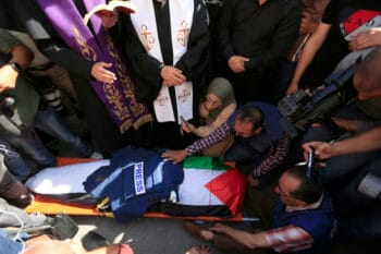 MOURNERS CARRY THE BODY OF AL JAZEERA REPORTER SHIREEN ABU AKLEH, WHO WAS KILLED BY ISRAELI ARMY GUNFIRE DURING AN ISRAELI RAID, DURING HER FUNERAL IN WEST BANK CITY OF JENIN ON MAY 11, 2022. (PHOTO: SHADI JARAR’AH/APA IMAGES)