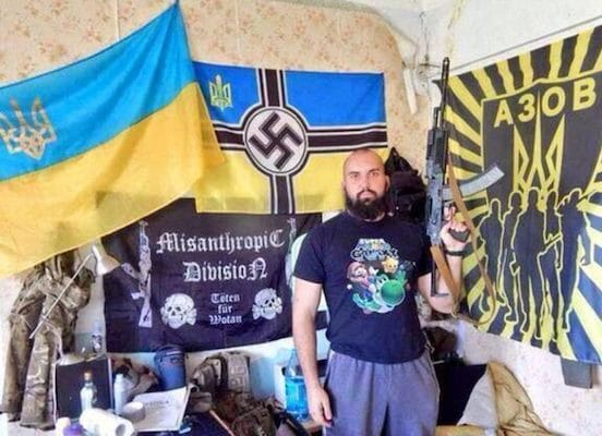 MR Online | Azov fighter posing in front of Nazi posters Mariupol Ukraine | MR Online