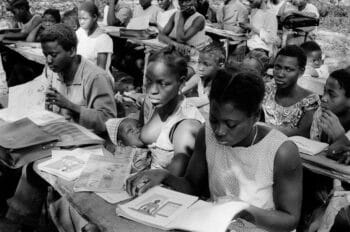 A student at a PAIGC semi-boarding primary school in the Sárà region reviews the mathematics textbook for grade one, produced for the Mozambique Liberation Front (FRELIMO) by Joachim Kindler and financed by the German Democratic Republic (DDR) under the International Solidarity Committee, 1974. Source: Roel Coutinho, Guinea-Bissau and Senegal Photographs (1973–1974)