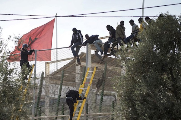 MR Online | African migrants sit on top of a border fence during an attempt to cross from Morocco into Spains north African enclave of Melilla November 21 2015 Photo ReutersJesus Blasco de AvellanedaFile Photo | MR Online