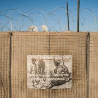 On a Kandahar outpost, a motivational poster on blast walls ringed with concertina wire, walling US troops off from Afghanistan. (File photo)