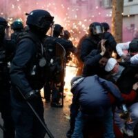 Activist protect themselves from riot police (Photo: AP/ Al Mayadeen)