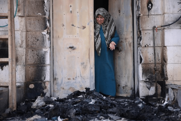 MR Online | A Palestinian woman examines damage caused by the Jewish settler pogrom in the town of Huwwara in the occupied West Bank Photo Oren Ziv via ActiveStillscom | MR Online