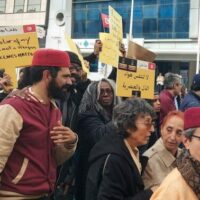 Mnemty team at the solidarity march denouncing racial discrimination and violence against sub-Saharan migrants in Tunis on 25 February 2023. Mnemty is a civil society organisation headed by Black Tunisian activist Saadia Mosbah (in photo holding the yellow sign in Arabic) who has been at the forefront of fighting all forms of anti-Black racism in Tunisia (Mahmoud Rassaa).