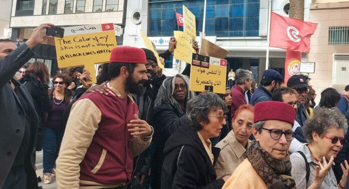Mnemty team at the solidarity march denouncing racial discrimination and violence against sub-Saharan migrants in Tunis on 25 February 2023. Mnemty is a civil society organisation headed by Black Tunisian activist Saadia Mosbah (in photo holding the yellow sign in Arabic) who has been at the forefront of fighting all forms of anti-Black racism in Tunisia (Mahmoud Rassaa).