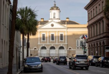 Traffic drives along Broad Street toward the Old Exchange and Provost Dungeon in Charleston the site of slave auctions Davila researched Public auctions were held outside on the building's north side.