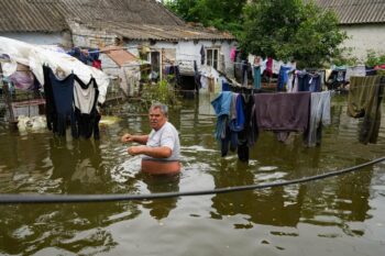 A man in the flooded yard of his house in Afanasiyivka Mykolayiv region on 10 June 2023 following the destruction of the Kakhovka dam AFP