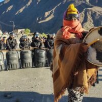 Indigenous woman in Jujuy playing drums in front of a police blockade as a sign of protest. Photo: Twitter/@PresentesLatam.