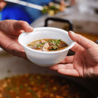 A person receiving a cup of soup in a street kitchen. Photo: File photo.