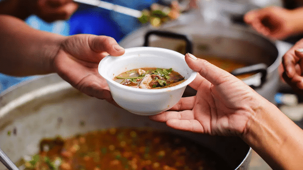 | A person receiving a cup of soup in a street kitchen Photo File photo | MR Online