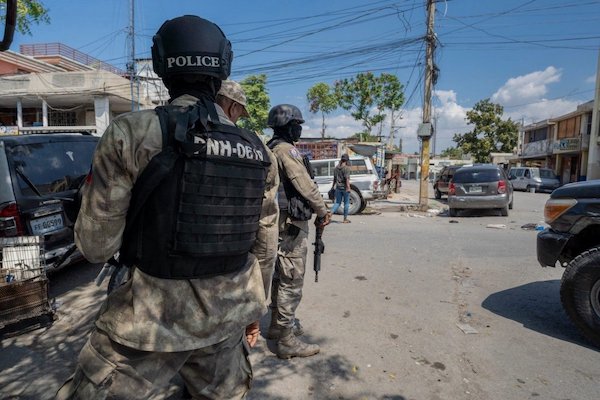 Police officers patrol a street in the Haitian capital of Port-au-Prince (courtesy Marvens Compère/Haitian Times)