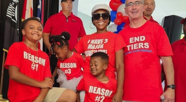 | Kiada Shanklin center a team leader in the quality department at Stellantiss Jeep Grand Cherokee plant posed with her three children and UAW President Shawn Fain at a contract rally on Sunday in Warren Michigan Her shirt says I have 3 major reasons to strike Photo UAW | MR Online