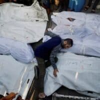 A mourner reacts amidst the bodies as people attend funeral for Palestinians killed in Israeli strikes in Khan Younis, southern Gaza Strip, on 24 October 2023 (Reuters)