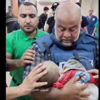 Palestinian journalist Wael Dahdouh cradles his child, killed by Israel while he was on air, October 27