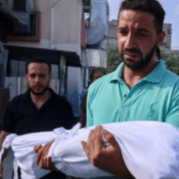 Father with body of his child killed by Israeli shelling in Khan Younis, October 10, 2023 (Photo: AFP)