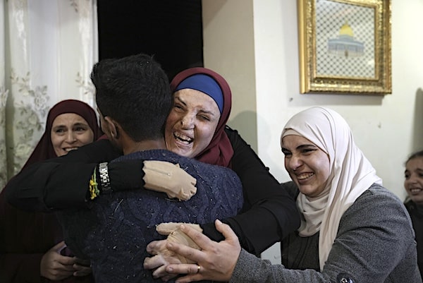 MR Online | Israa Jaabis center a Palestinian prisoner released by Israel is hugged by relatives as she arrived home in East Jerusalem Nov 26 2023 | MR Online