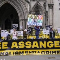 Demonstrators hold banners outside the Royal Courts of Justice in London, February 20, 2024