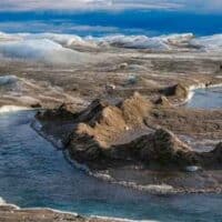  | Drainage system with dirt cone on the surface of the ice sheet The brown sediment on the ice is created by the rapid melting of the ice Landscape of the Greenland ice sheet near Kangerlussuaq Martin ZwickREDACOUniversal Images Group via Getty Images | MR Online